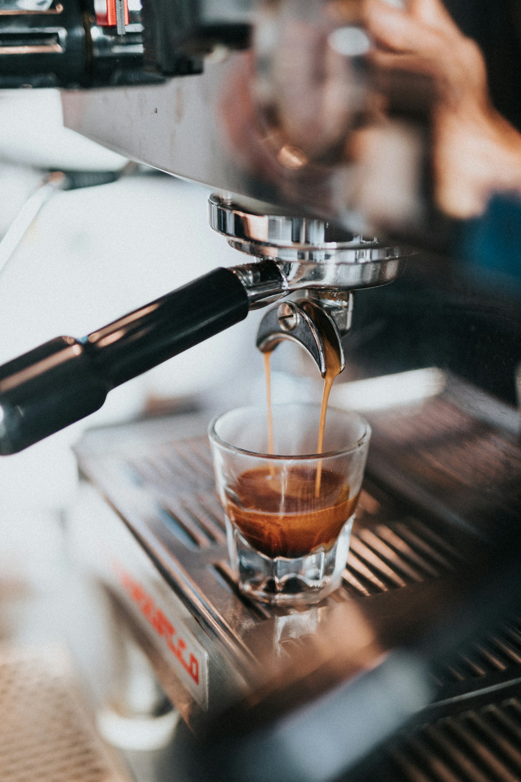 Espresso cayendo de un portafiltro en un vaso
