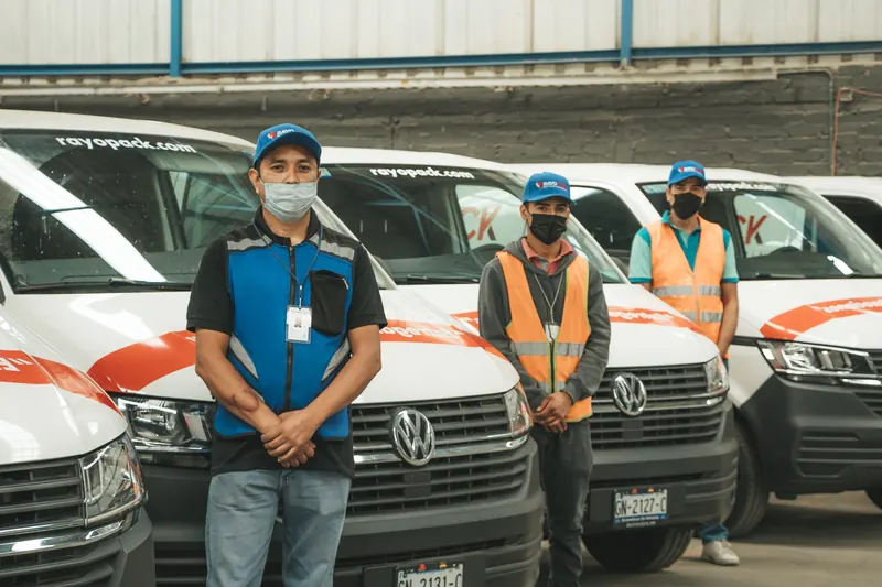 Equipo de Rayo Pack frente a la flotilla de camionetas